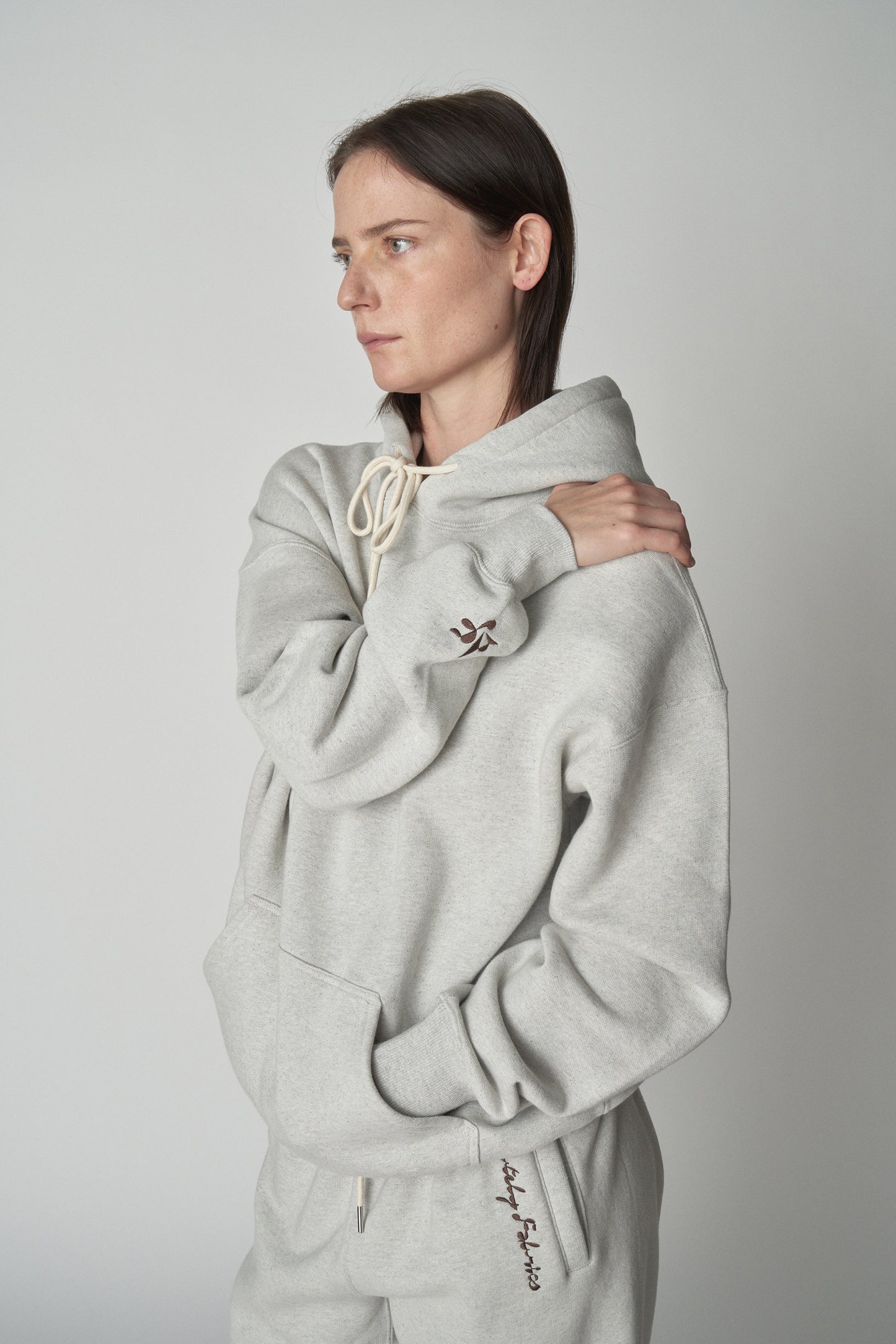 Torso view of model wearing grey Absolutely Fabrics hoodie.