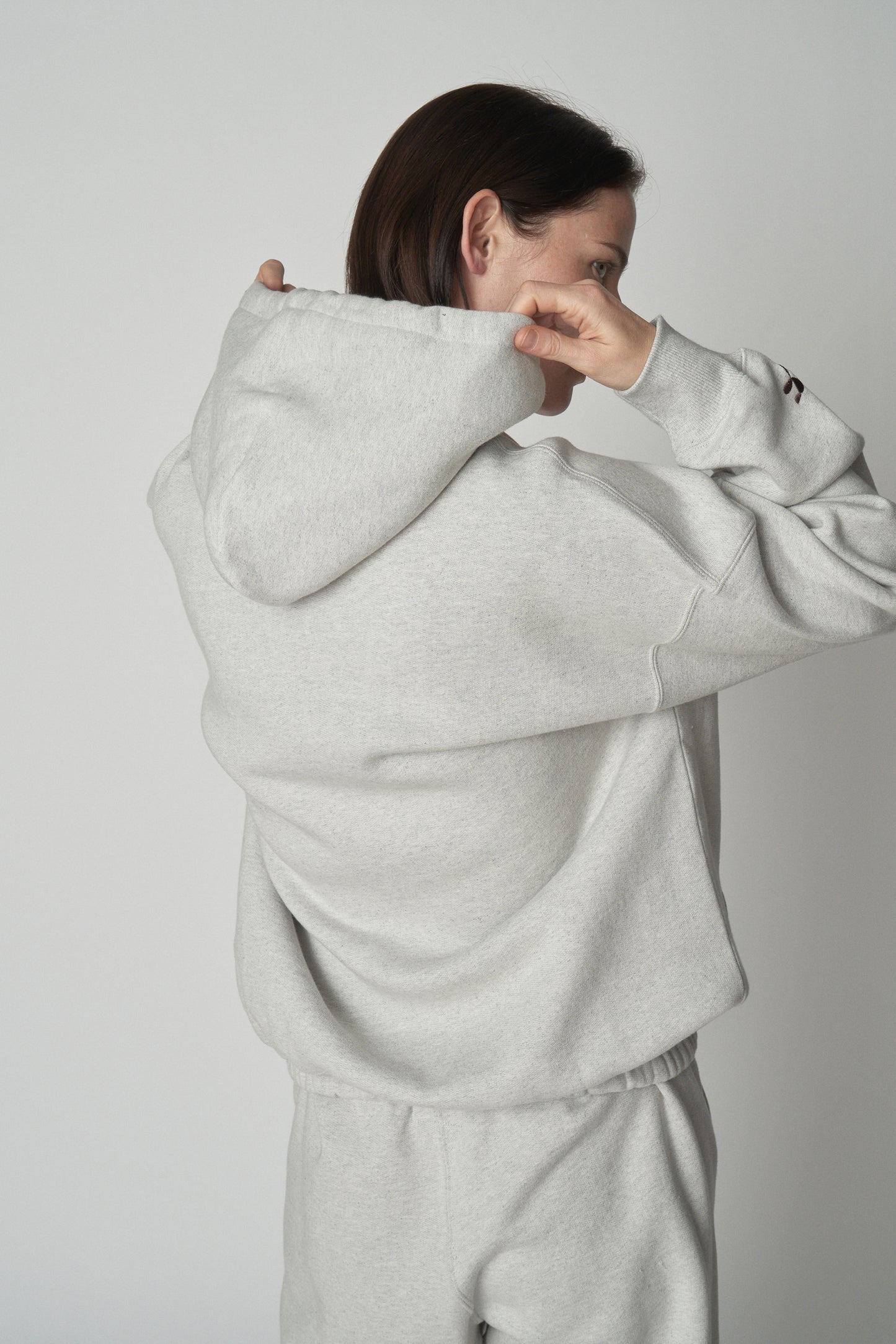 Back torso view of model wearing grey Absolutely Fabrics hoodie.