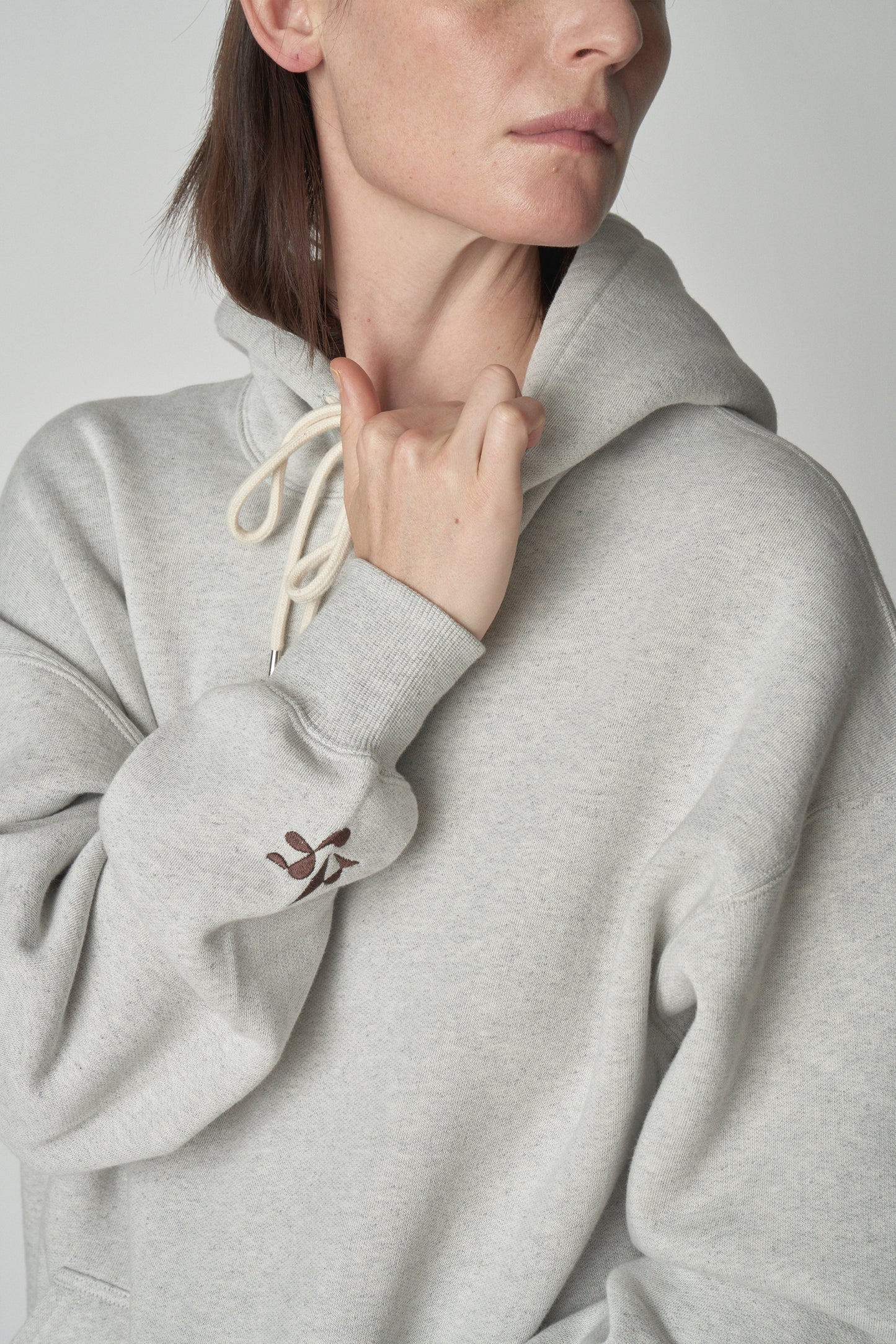 Torso view of model wearing grey Absolutely Fabrics hoodie.