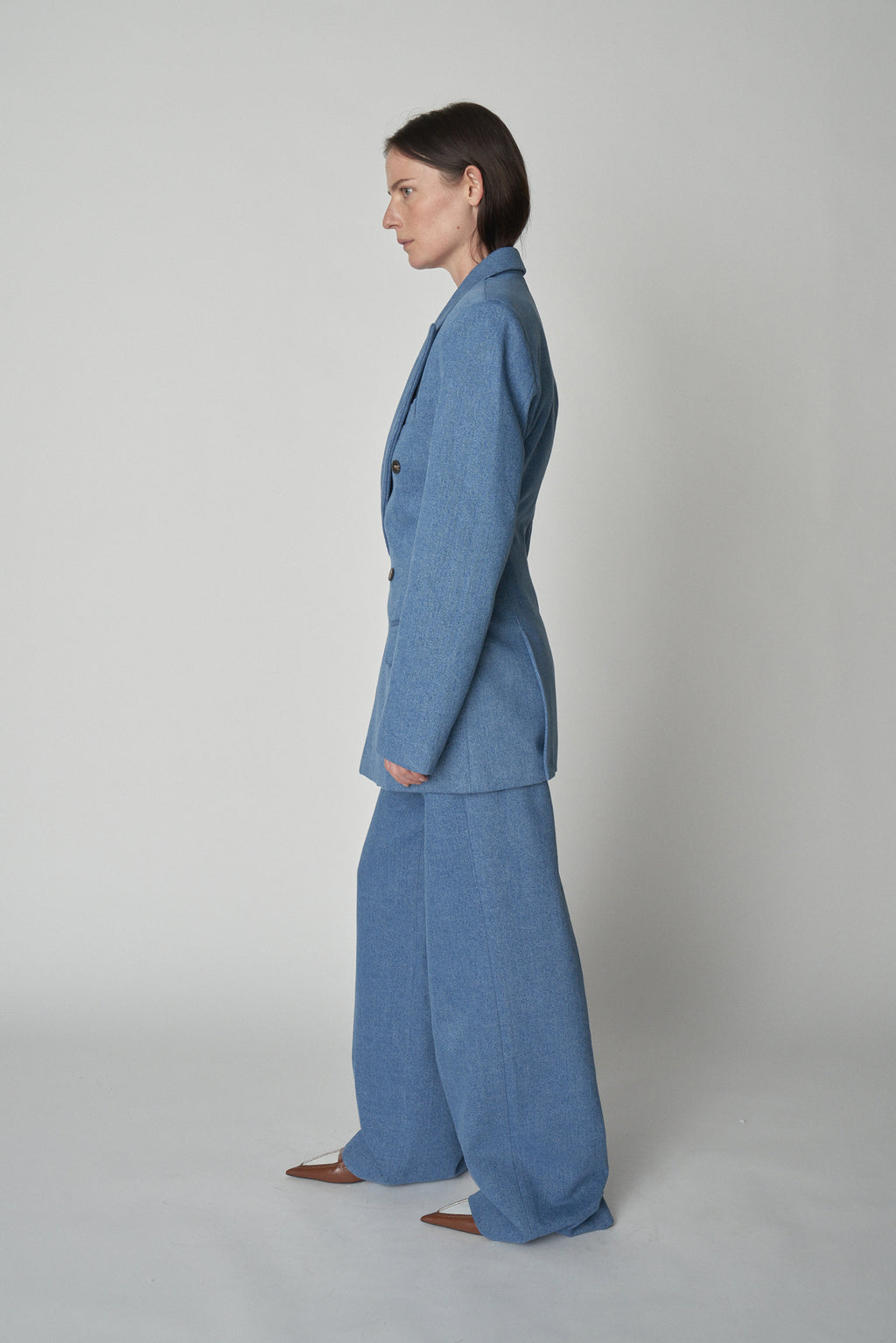 Full side view of model wearing Bettter denim blazer and trouser.
