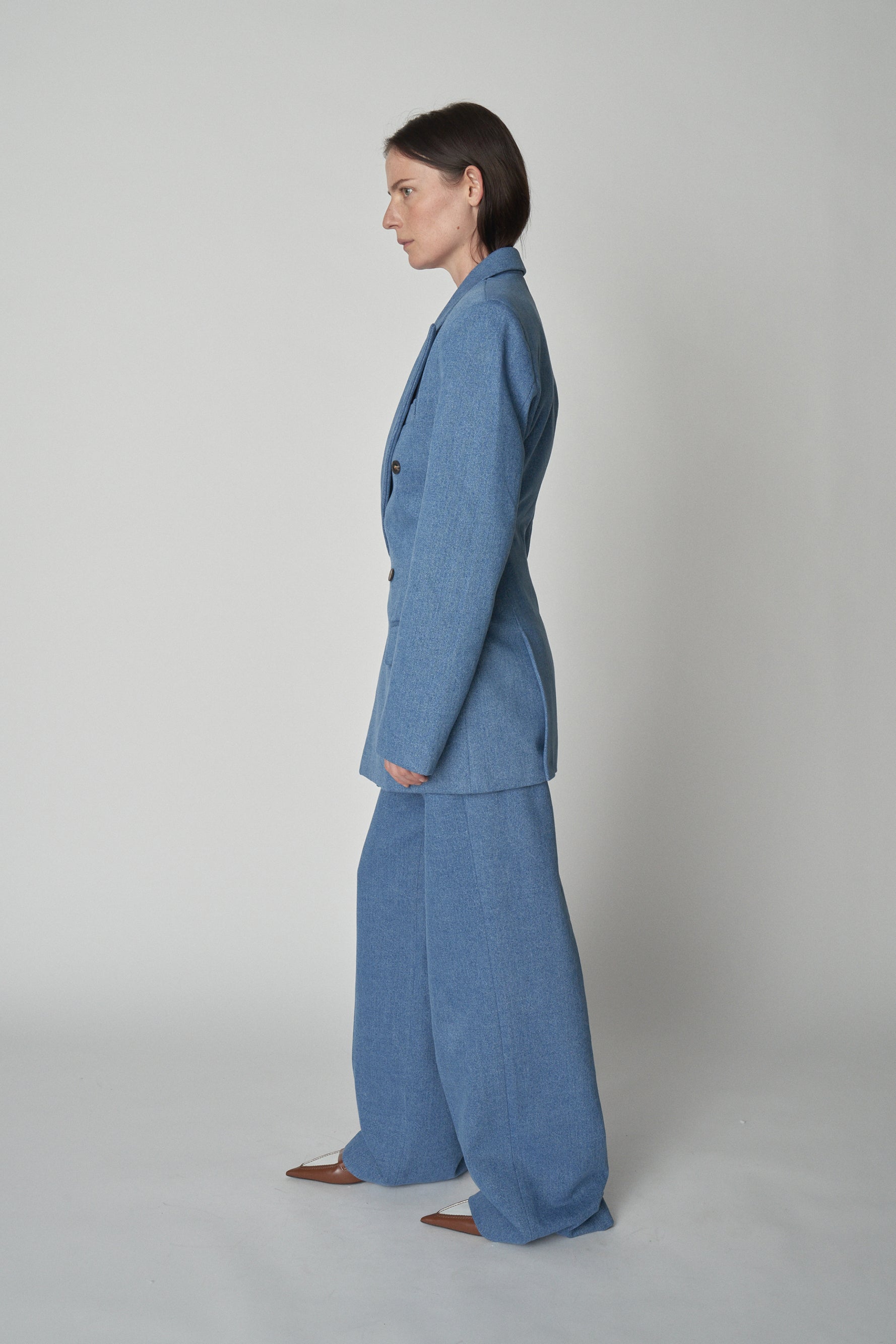 Full side view of model wearing Bettter denim blazer and trouser.