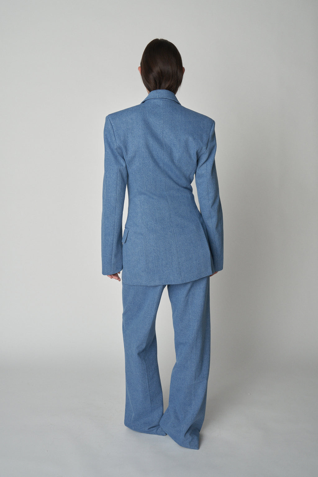 Full back view of model wearing Bettter denim blazer and trouser.