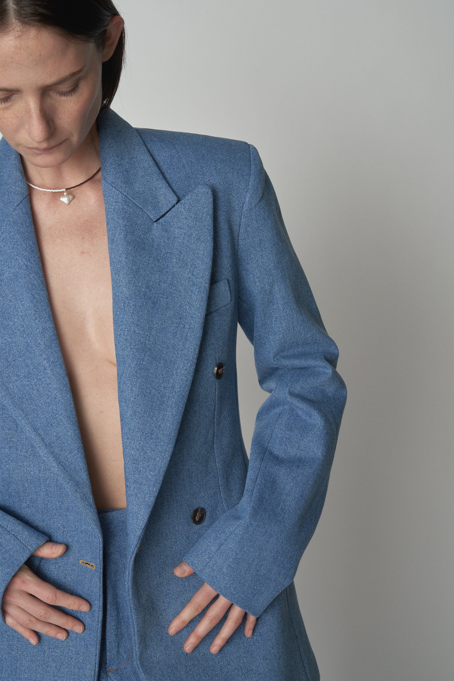 Detail shot of model wearing Bettter denim blazer and trouser.