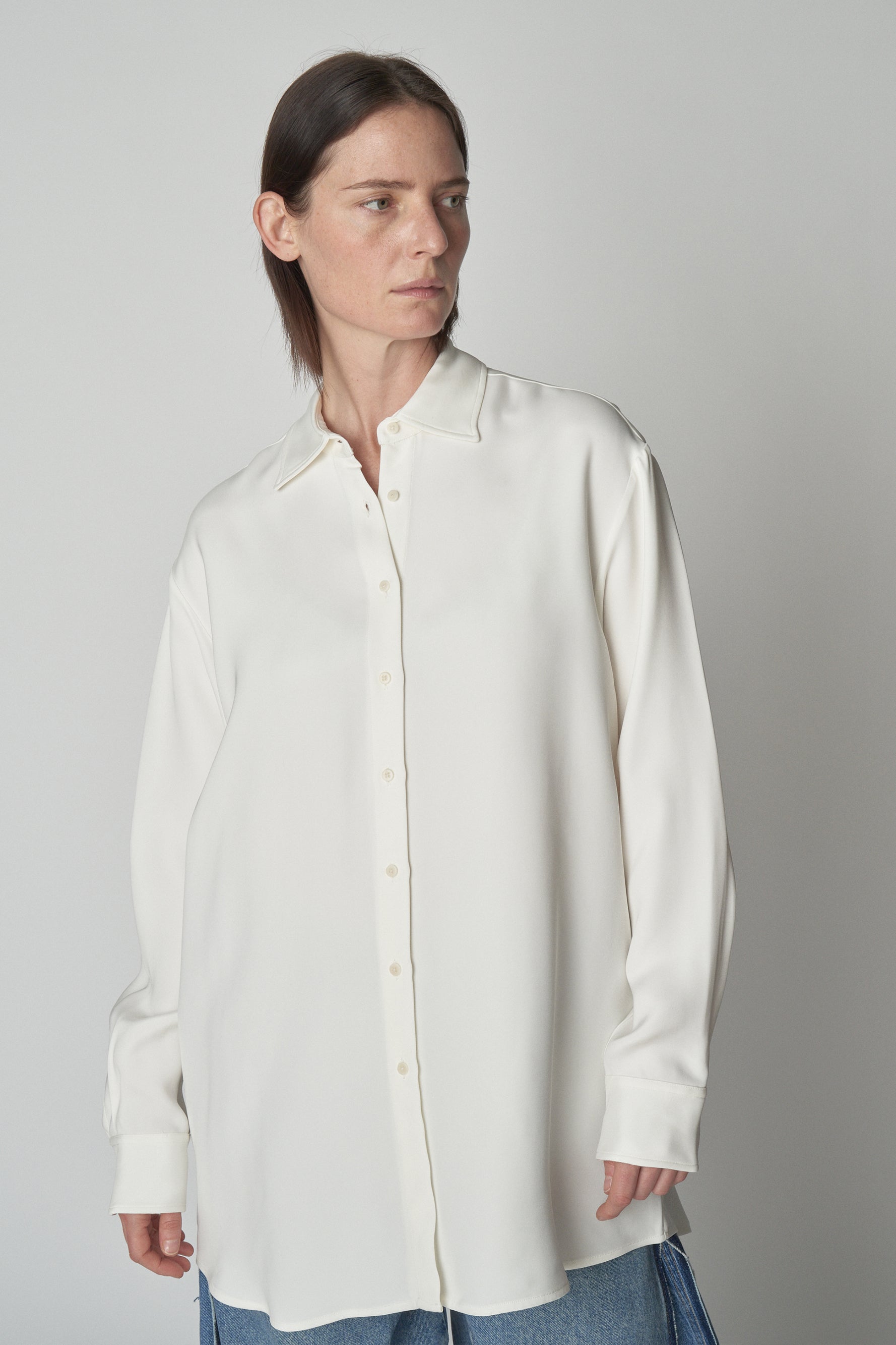 Front torso view of model wearing relaxed white shirt. 