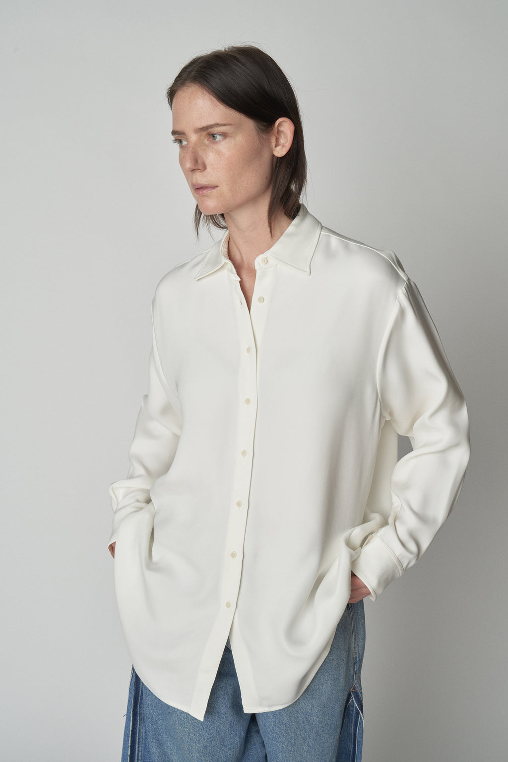 Front torso view of model wearing relaxed white shirt. 