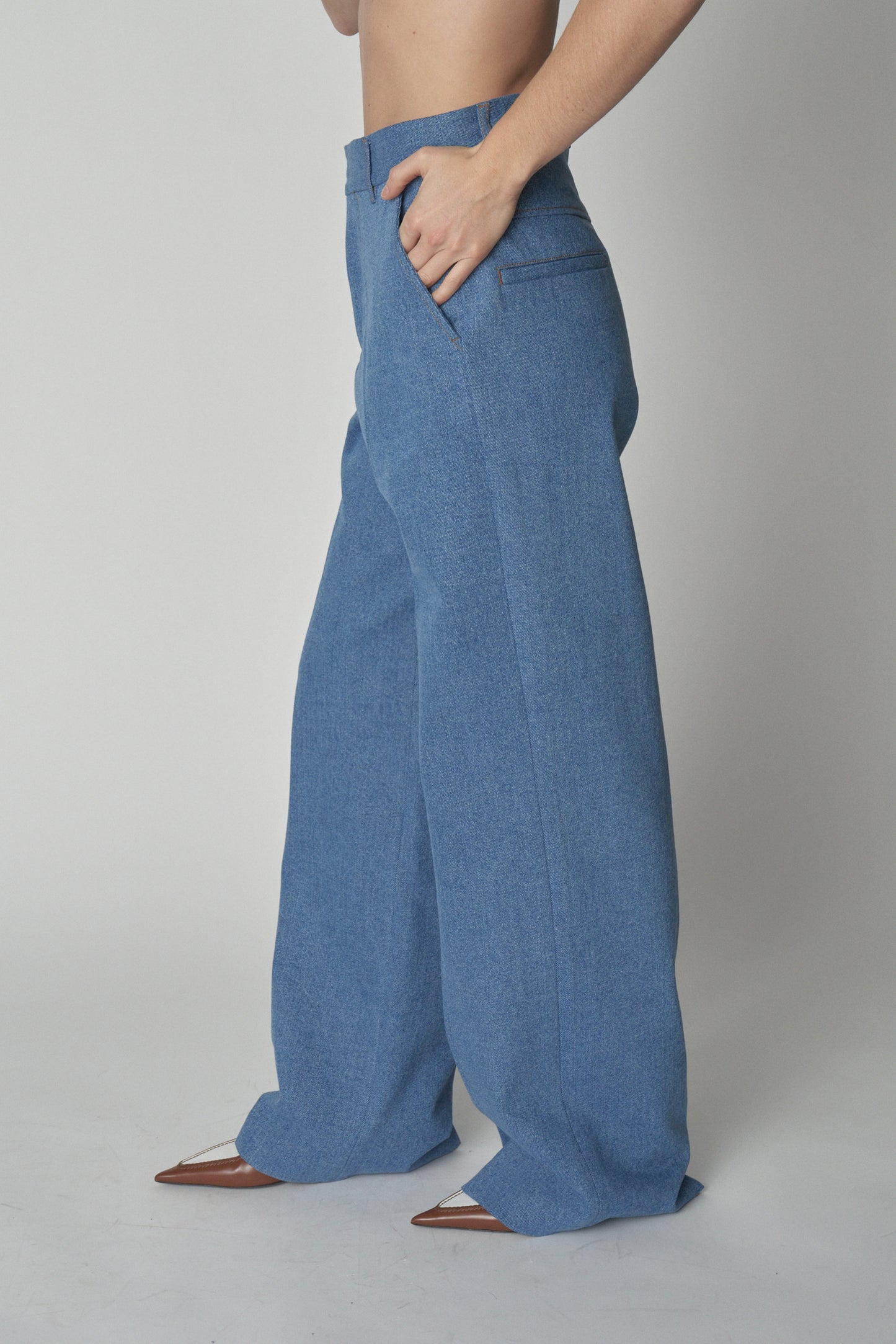 Side waist down view of model wearing Bettter denim trousers.