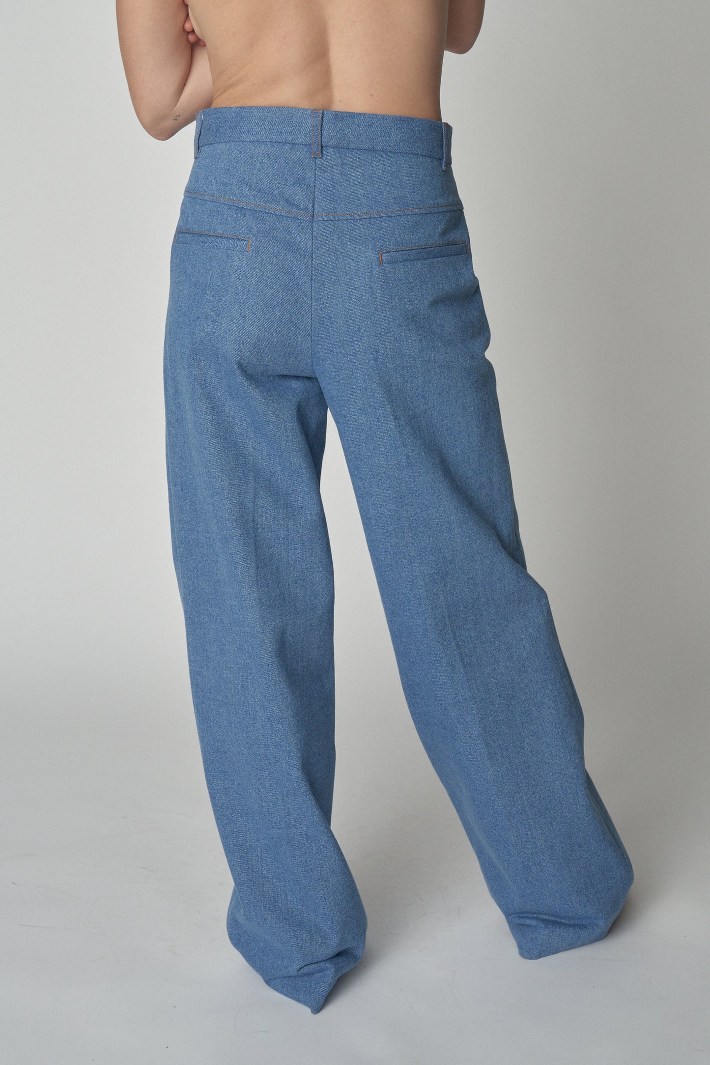 Back waist down view of model in denim trousers.