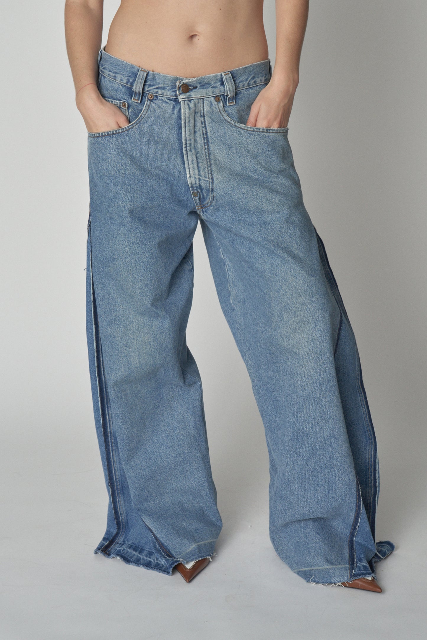 Front view of model wearing wide leg jeans with additional denim panel.