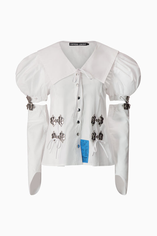 White blouse with puff sleeve, sailor collar, and silver hardware. 