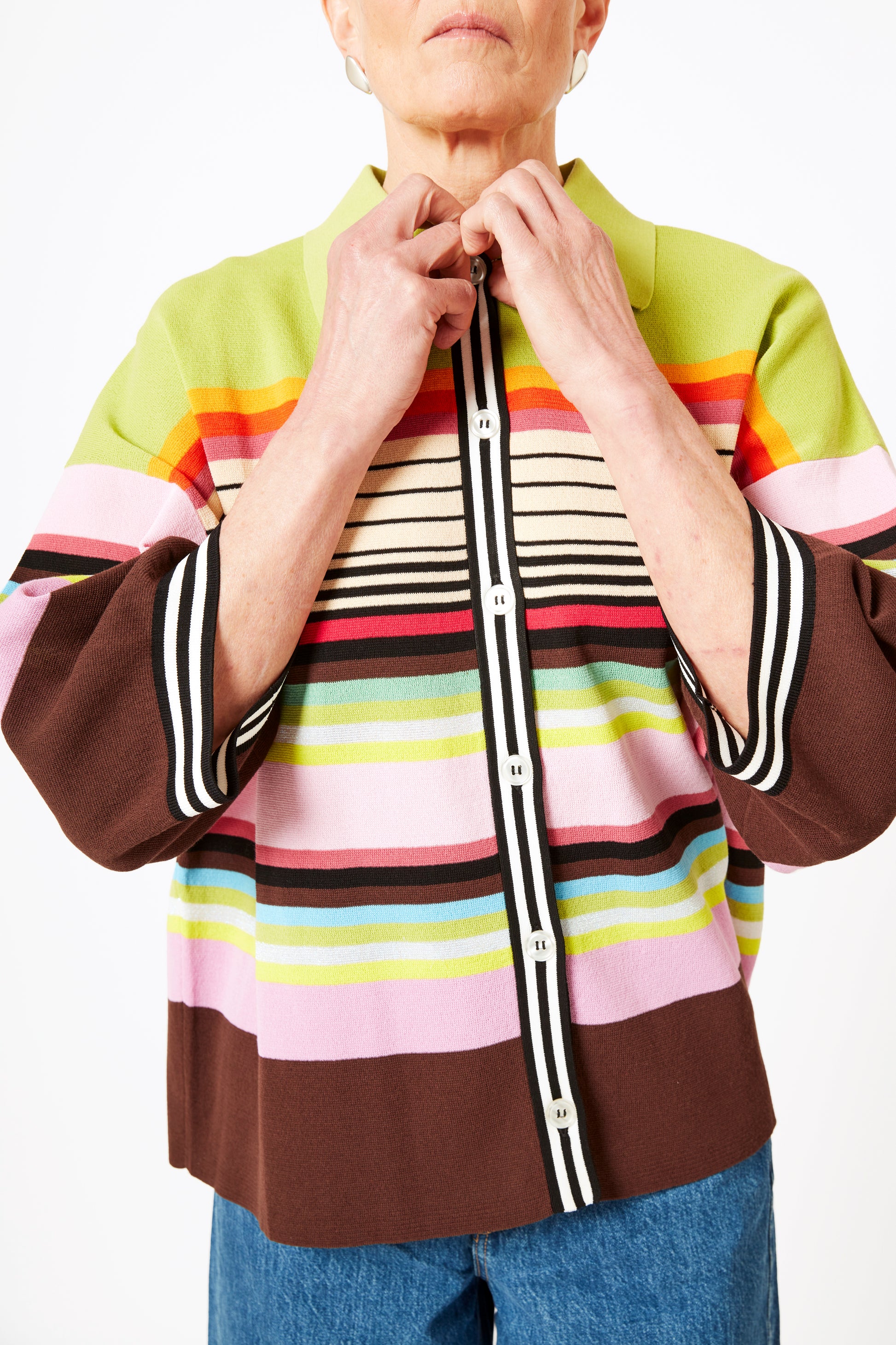 Detail shot of model wearing knit polo with graphic stripes and 3/4 sleeves.